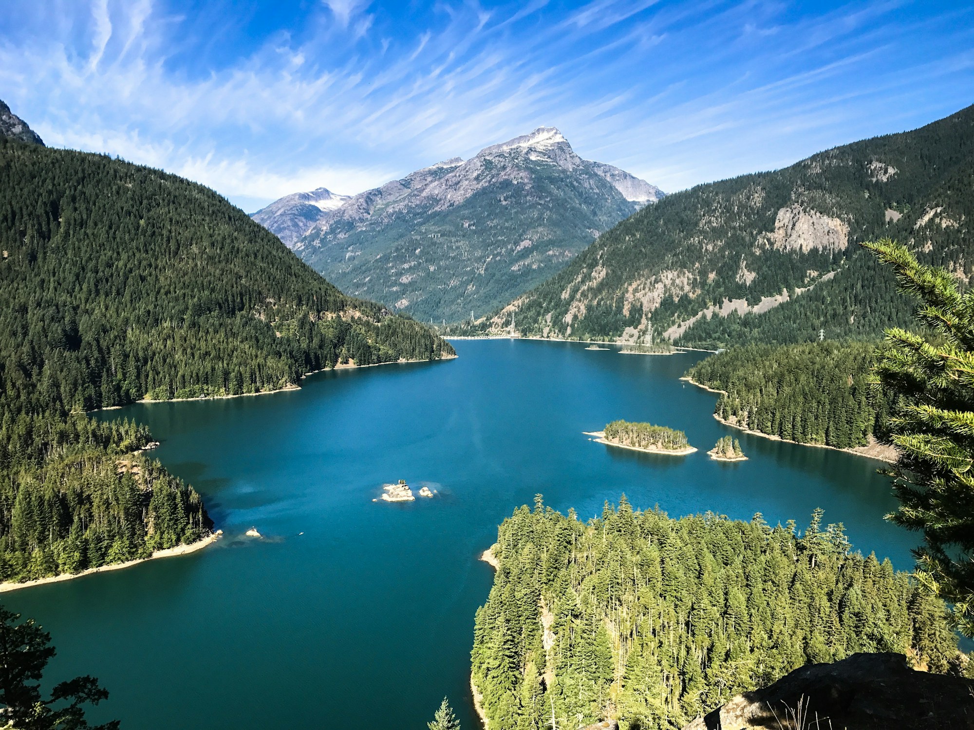 Deep blue lake ringed by forested mountains